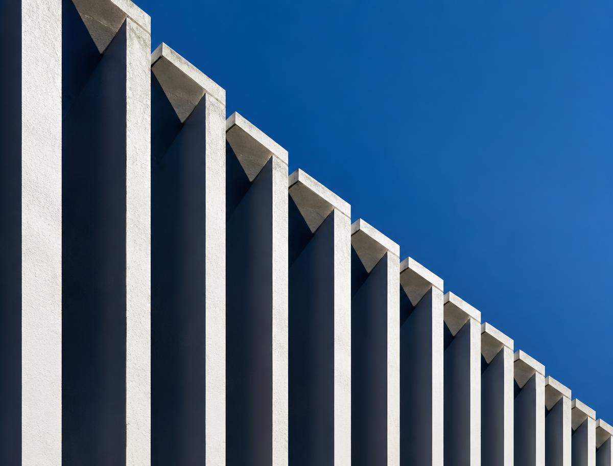 Repeating white architectural fins against blue sky